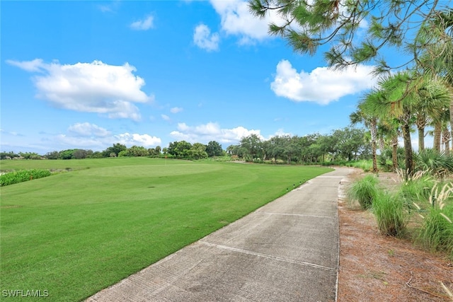 view of community with golf course view and a lawn