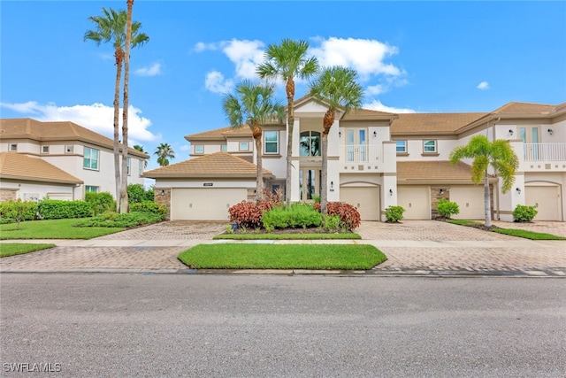 view of front of home featuring a residential view, stucco siding, decorative driveway, and a balcony