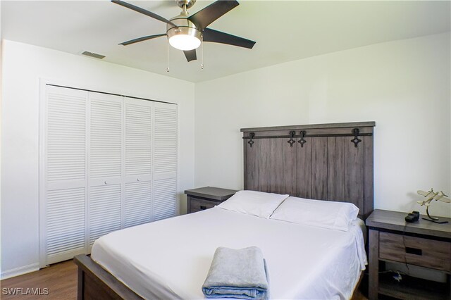 bedroom with dark hardwood / wood-style flooring, ceiling fan, and a closet