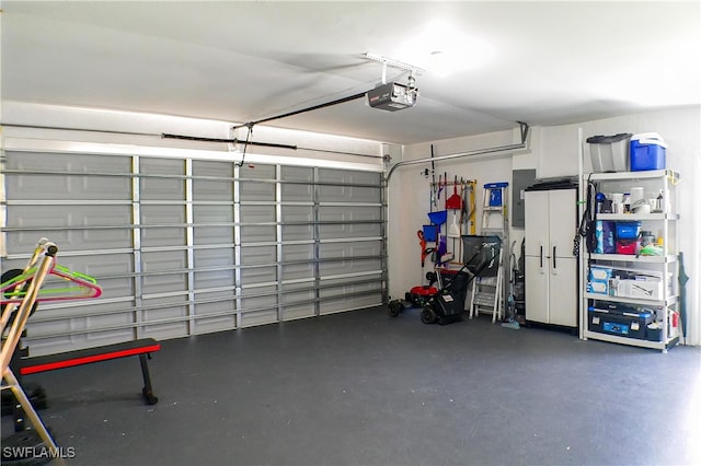 garage with a garage door opener and electric panel