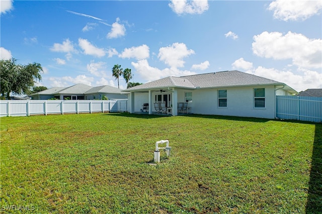 rear view of property with a yard