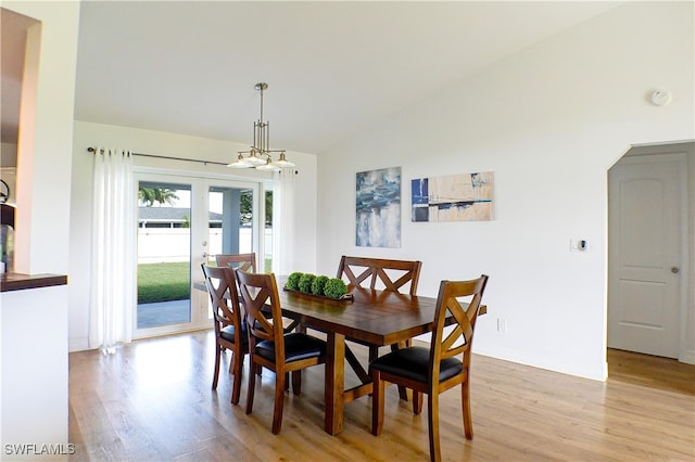 dining area with light wood-type flooring and lofted ceiling