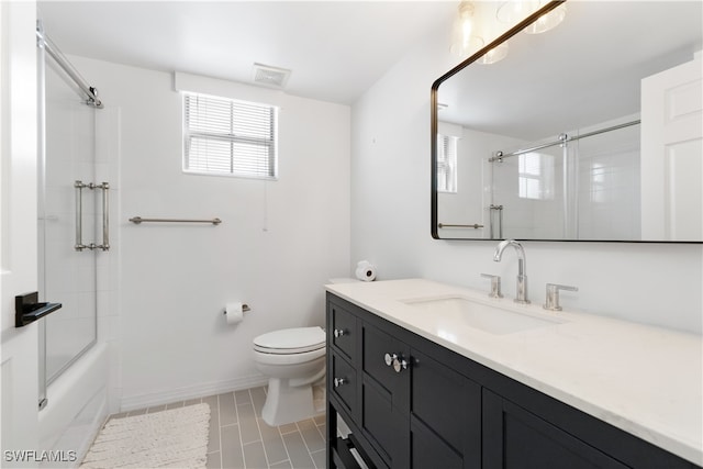 full bathroom with tile patterned floors, toilet, combined bath / shower with glass door, and vanity