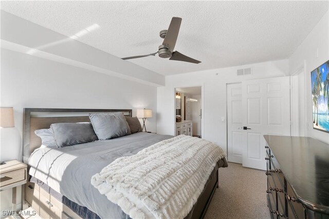 carpeted bedroom with a textured ceiling, ceiling fan, and ensuite bathroom