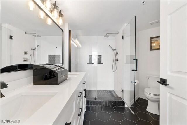 bathroom featuring tile patterned flooring, walk in shower, toilet, and vanity