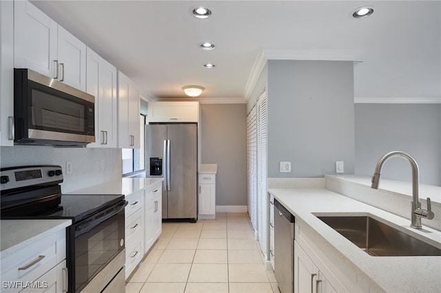 kitchen with light tile patterned floors, light stone counters, sink, appliances with stainless steel finishes, and white cabinets