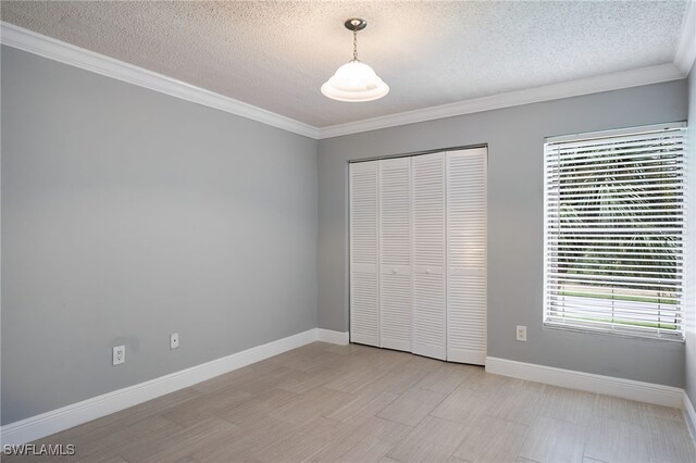 7012 Constitution Blvd Unit 206, Fort Myers, FL 33967 - unfurnished bedroom featuring a textured ceiling, ornamental molding, and a closet