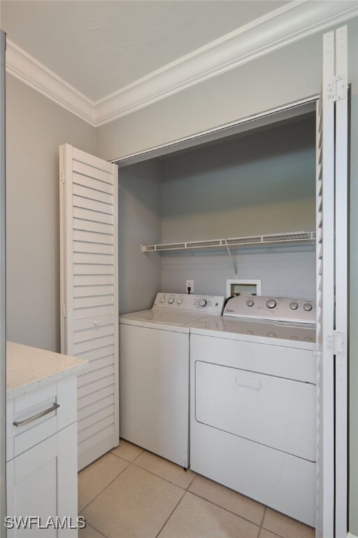 7012 Constitution Blvd Unit 206, Fort Myers, FL 33967 - clothes washing area with crown molding, light tile patterned floors, laundry area, and independent washer and dryer