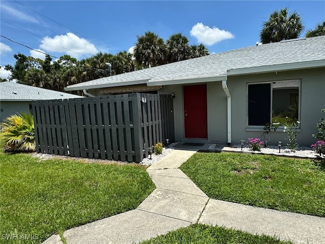 view of exterior entry with a lawn