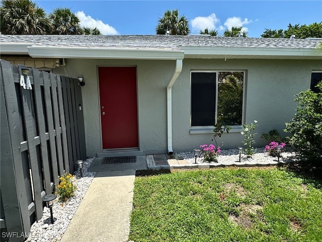 entrance to property featuring a lawn