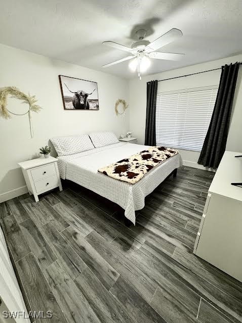 bedroom with ceiling fan and dark hardwood / wood-style floors