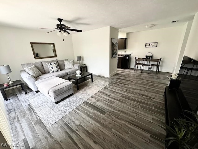 living room with ceiling fan and dark hardwood / wood-style flooring