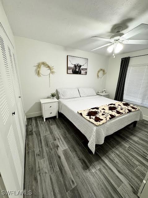 bedroom featuring a closet, dark wood-type flooring, and ceiling fan