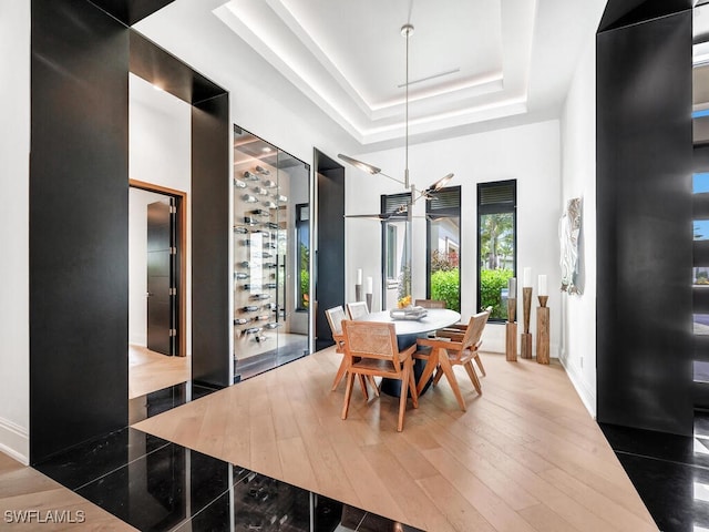 dining area featuring hardwood / wood-style flooring and a raised ceiling