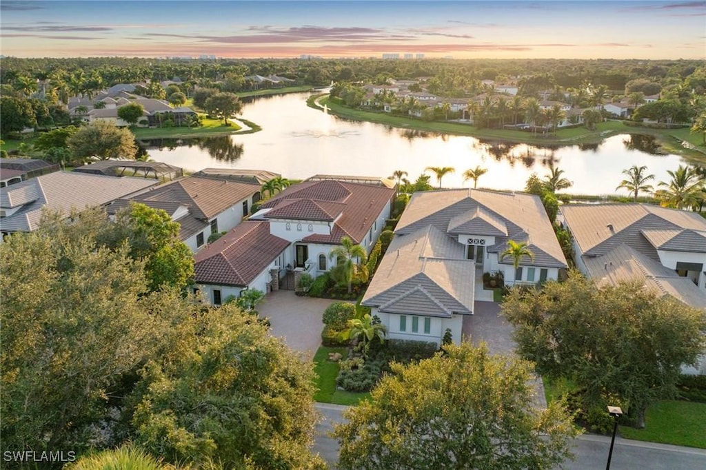 aerial view at dusk featuring a water view