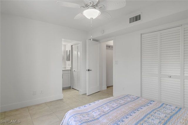 tiled bedroom with connected bathroom and ceiling fan