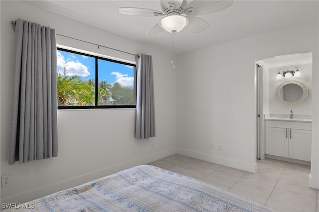 unfurnished bedroom featuring ensuite bath, light tile patterned flooring, sink, and ceiling fan