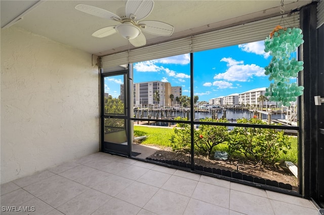 unfurnished sunroom with a water view and ceiling fan