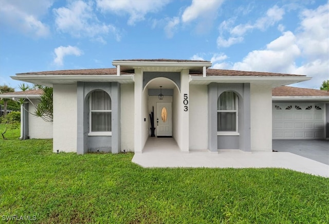 view of front of home with a front yard and a garage