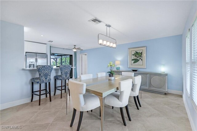 dining room with ceiling fan with notable chandelier and light tile patterned floors