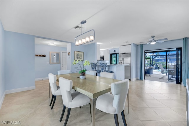 tiled dining area with ceiling fan with notable chandelier