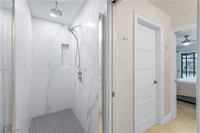 bathroom featuring a tile shower, ceiling fan, and a textured ceiling