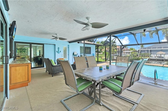 view of patio / terrace with sink, a lanai, and ceiling fan