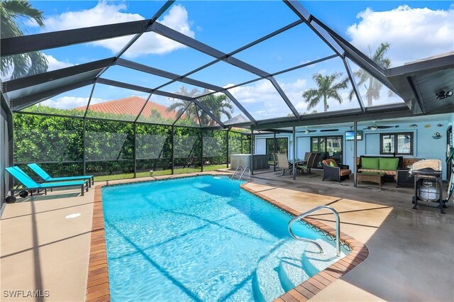 view of swimming pool featuring an outdoor living space, a patio, ceiling fan, and a lanai