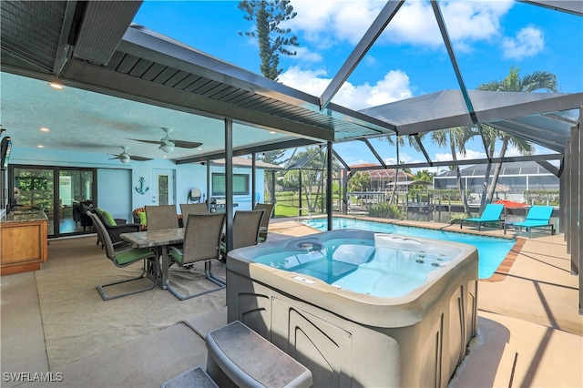 view of patio featuring ceiling fan, a pool with hot tub, and glass enclosure