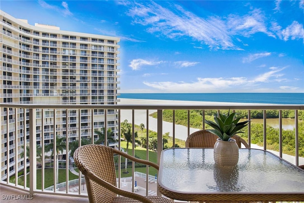 balcony featuring a water view and a beach view