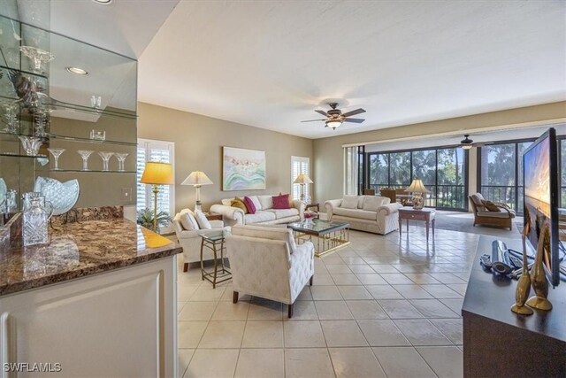 living room with light tile patterned floors, plenty of natural light, and ceiling fan