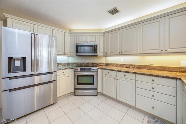 kitchen featuring light tile patterned flooring, white cabinetry, and appliances with stainless steel finishes