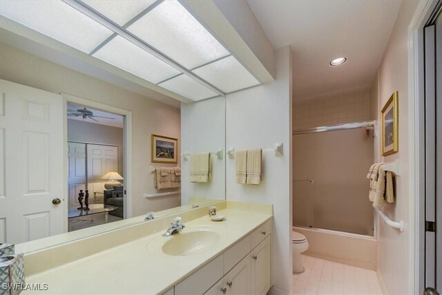 full bathroom with ceiling fan, tile patterned floors, bath / shower combo with glass door, toilet, and vanity