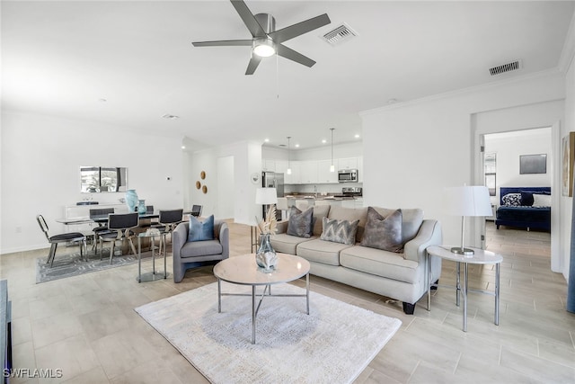 living room featuring ornamental molding and ceiling fan