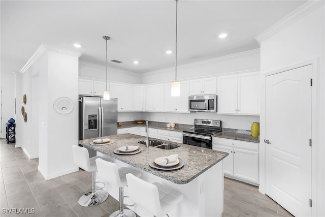 kitchen with stainless steel appliances, an island with sink, sink, hanging light fixtures, and a breakfast bar area