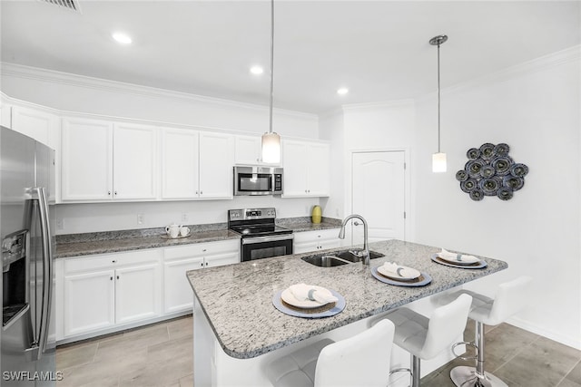 kitchen with white cabinets, stainless steel appliances, sink, a kitchen bar, and a kitchen island with sink