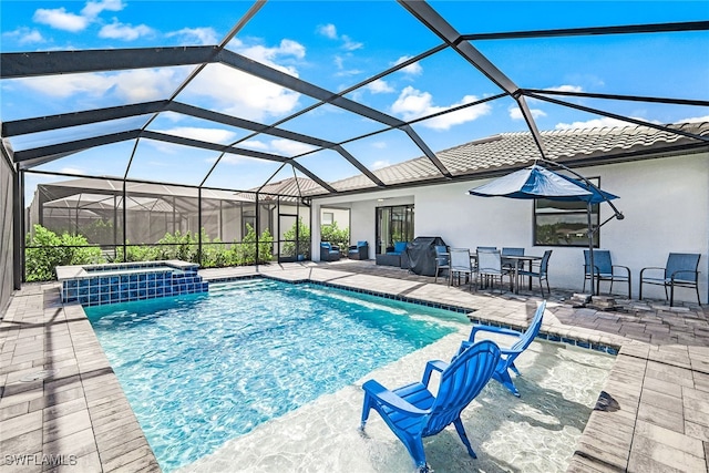 view of pool with glass enclosure, an in ground hot tub, and a patio area