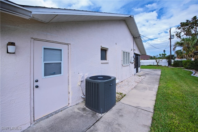 view of property exterior with cooling unit and a lawn