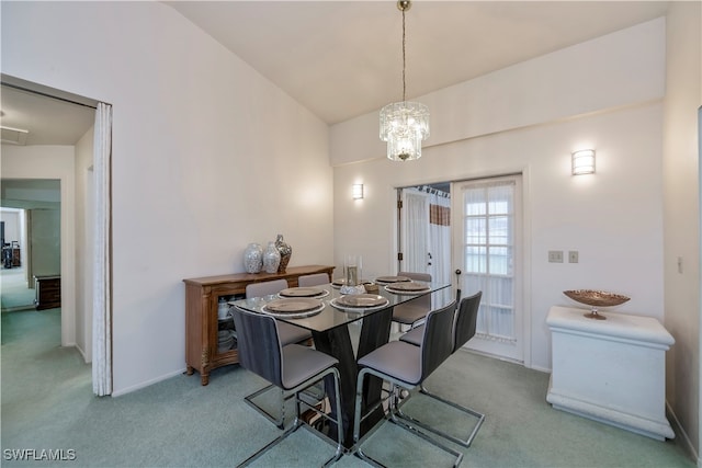 dining area with lofted ceiling, an inviting chandelier, and light colored carpet