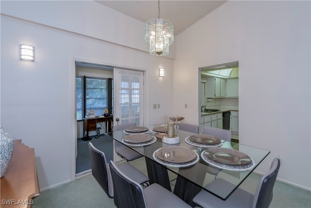 carpeted dining area with a notable chandelier, sink, and lofted ceiling