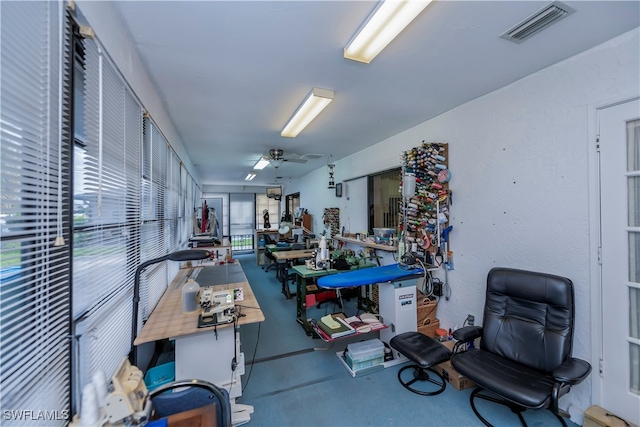 interior space featuring ceiling fan and concrete floors