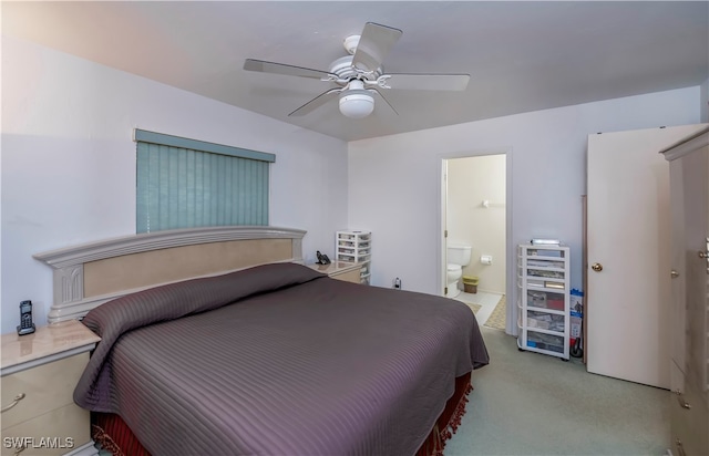 bedroom featuring connected bathroom, light colored carpet, and ceiling fan