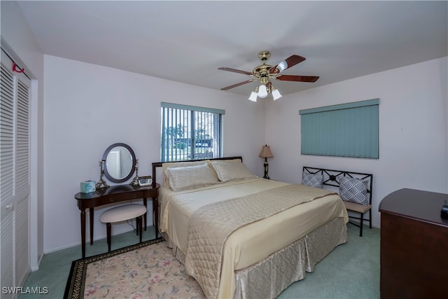 bedroom featuring a closet, light colored carpet, and ceiling fan