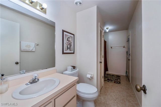 bathroom with vanity, toilet, and tile patterned flooring