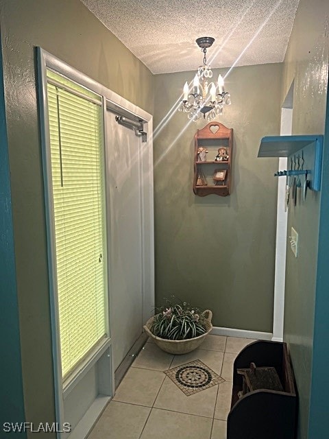 interior space featuring a textured ceiling, a chandelier, and light tile patterned flooring