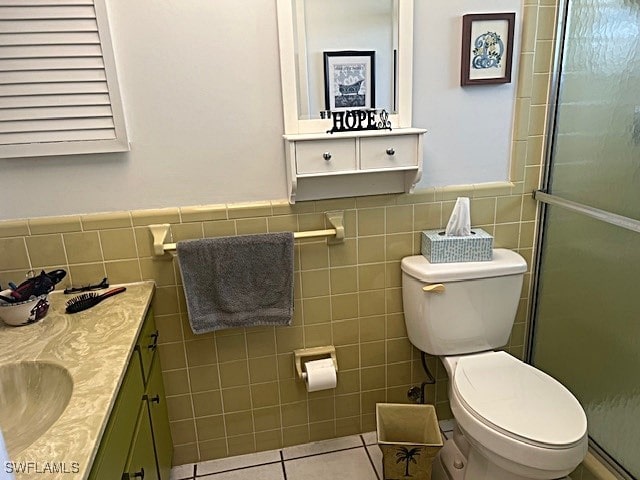 bathroom featuring an enclosed shower, tile walls, toilet, and vanity