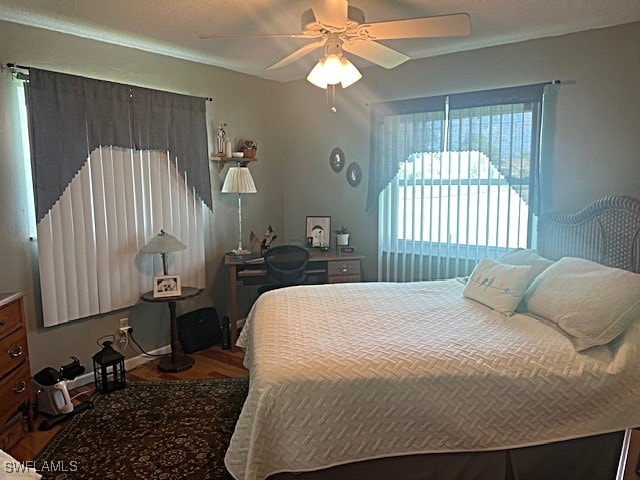 bedroom with a textured ceiling, hardwood / wood-style floors, and ceiling fan