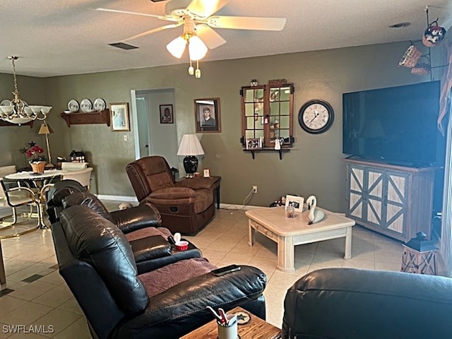 living room featuring a textured ceiling, light tile patterned floors, and ceiling fan with notable chandelier