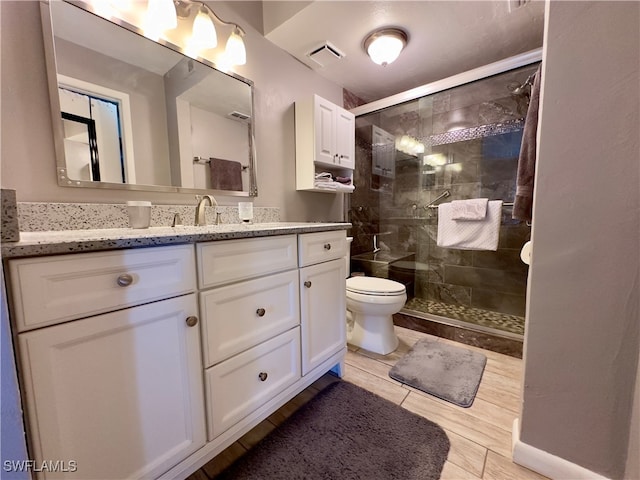 bathroom featuring wood-type flooring, vanity, toilet, and walk in shower