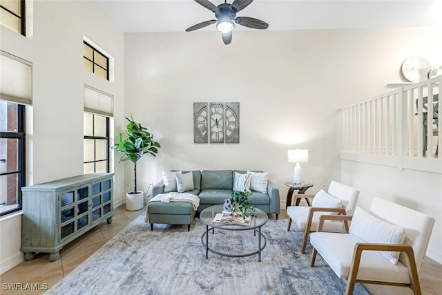 living room featuring light tile patterned floors, a towering ceiling, and ceiling fan